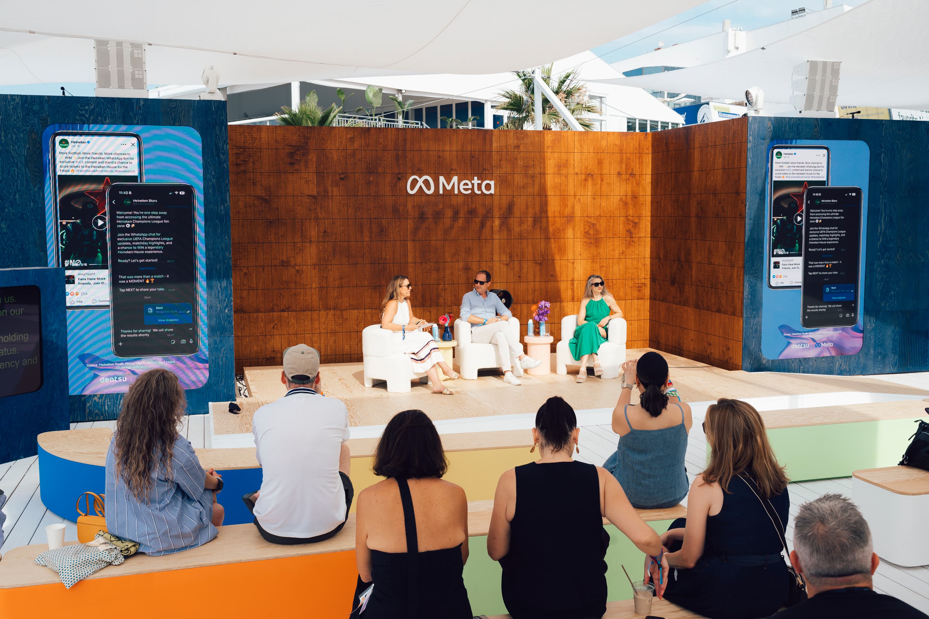 image of three people sitting on a stage with audience looking on