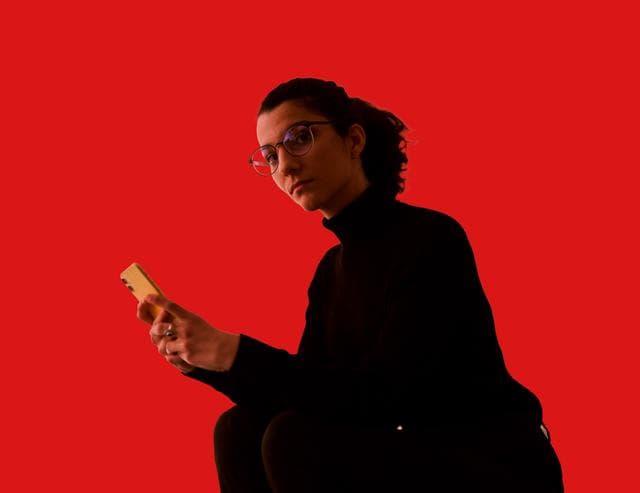 woman with phone looking at camera
